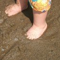 Baby Feet Buried In The Beach Sand Baby Feet Buried In The Beach Sand